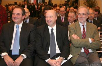 Ο Αντρέας Δρακόπουλος, Πρόεδρος του Ιδρύματος Σταύρος Νιάρχος, κάθεται ανάμεσα από δύο άντρες και παρακολουθούν μια ομιλία